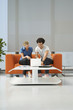 Two people using laptop in reception room