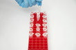 Scientist picking up test tube with tweezers indoors, close-up of hand