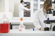 Photo: Scientist using microscope with second scientist looking in refrigerator in laboratory Scientist using microscope with second scientist looking in refrigerator in laboratory