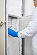 Scientist reaching into freezer in laboratory