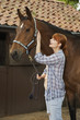 Woman with horse outside stable