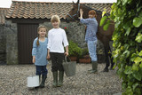 Photo: Sister and brother 5-6, 7-9 holding buckets, mother with horse by stable, portrait Sister and brother 5-6, 7-9 holding buckets, mother with horse by stable, portrait