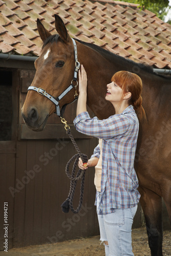 Photo: Woman with horse outside stable Woman with horse outside stable