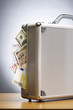 Metal briefcase full of cash on table
