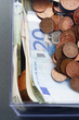Plastic moneybox with Coins and paper Euro currency, view from above