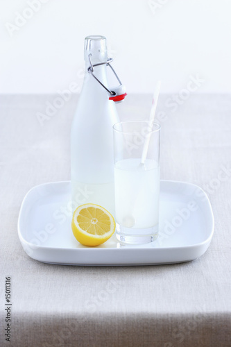 Photo: Ceramic bottle, lemonade glass and lemon on tray Ceramic bottle, lemonade glass and lemon on tray