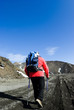 one hiker with poles walking footpath