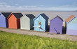 Woman jumping in front of beach hut
