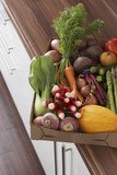 Photo: Container full of fresh vegetables on kitchen counter, close-up, elevated view Container full of fresh vegetables on kitchen counter, close-up, elevated view
