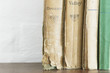 Stack of old books on wooden chest, close up