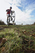 Man performing wheeley on mountain bike in countryside