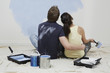 Couple looking up at half-painted wall