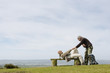 Man Helping Girlfriend up from a Park Bench