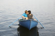 Young Couple Cuddling in Rowboat on Lake