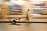 Photo: dubai uae a man wheels an empty cart through the streets of deira just after dark. dubai uae a man wheels an empty cart through the streets of deira just after dark.
