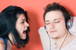 A man listening to music while a woman shouting at him