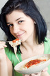 Young woman eating pasta in the kitchen Young woman eating pasta in the kitchen