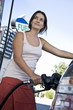 Smiling woman refueling car at natural gas station