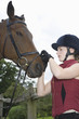 Girl tightening horse's bridle