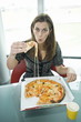 Businesswoman eating pizza at desk