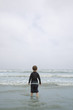 Young Boy Standing in Surf