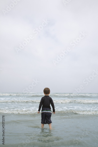 Photo: Young Boy Standing in Surf Young Boy Standing in Surf