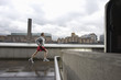 Foto: Man joggin along the Thames with the Tate Modern in the background Man joggin along the Thames with the Tate Modern in the background