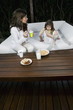Young woman and girl having breakfast outdoors