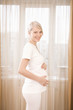 Pregnant woman by window, portrait