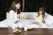 Young woman and girl having breakfast outdoors