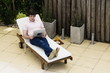Young man reading by the swimming pool