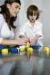 Young woman and boy playing with building blocks