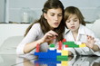 Young woman and boy playing with building blocks