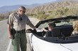 Police officer examines papers of convertible driver