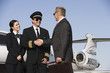 Mid-adult airline pilot and senior businessman shaking hands.