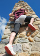 Woman climbing a stone pillar