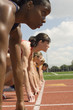 Group of female track athletes on starting blocks