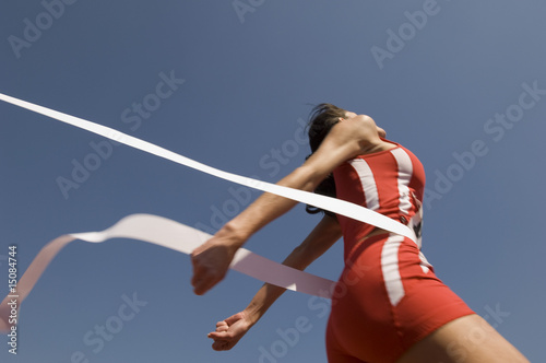 Photo: female track athlete crossing finishing line female track athlete crossing finishing line