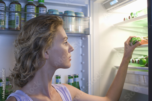 Photo: Young woman looking for food in fridge Young woman looking for food in fridge