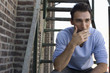 Young Man Smoking on Fire Escape