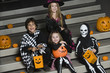 Portrait of boys and girls 7-9 wearing Halloween costumes on steps