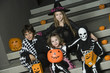 Portrait of boys and girls 7-9 wearing Halloween costumes on steps