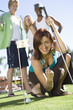 Young Woman Playing Mini Golf with Friends