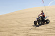 young man on atv on sand dune
