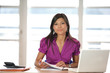 Femme souriante assise à un bureau avec documents Femme souriante assise à un bureau avec documents