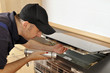 Foto: Handwerker untersucht Kochfeld Handwerker untersucht Kochfeld