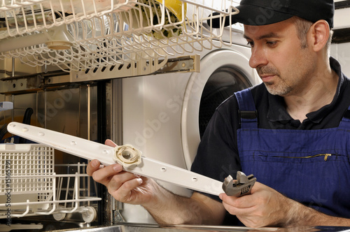 Foto: Handwerker repariert Spülmaschine Handwerker repariert Spülmaschine