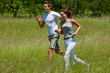 Man and woman jogging in a meadow