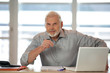 Homme assis à un bureau devant un ordinateur portable