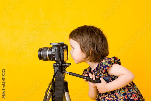 Foto: Baby girl holding photo camera Baby girl holding photo camera